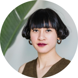 Woman with blunt bangs and hoop earrings